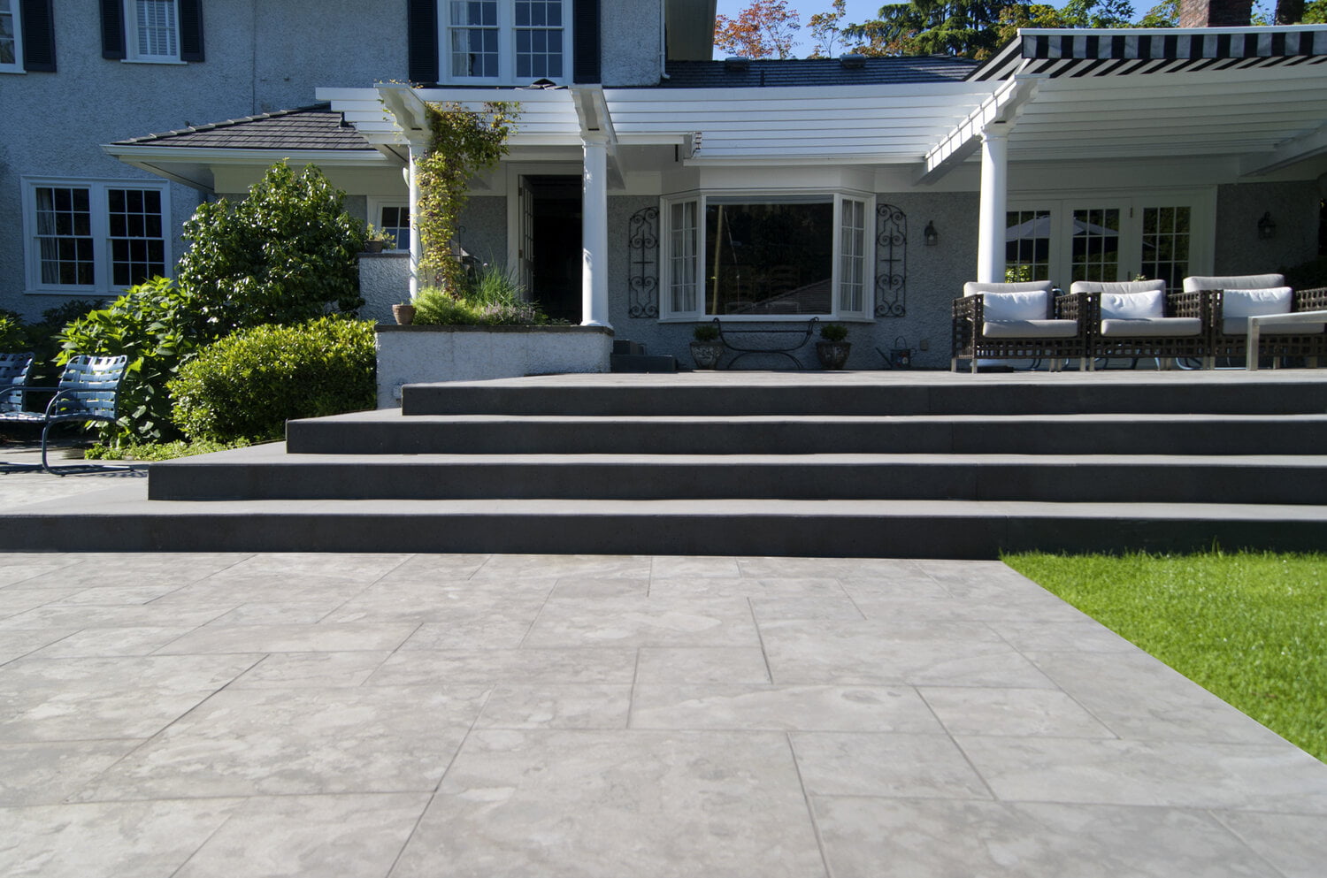 Stone tile pool terrace and architectural concrete stairs at residential landscape design project