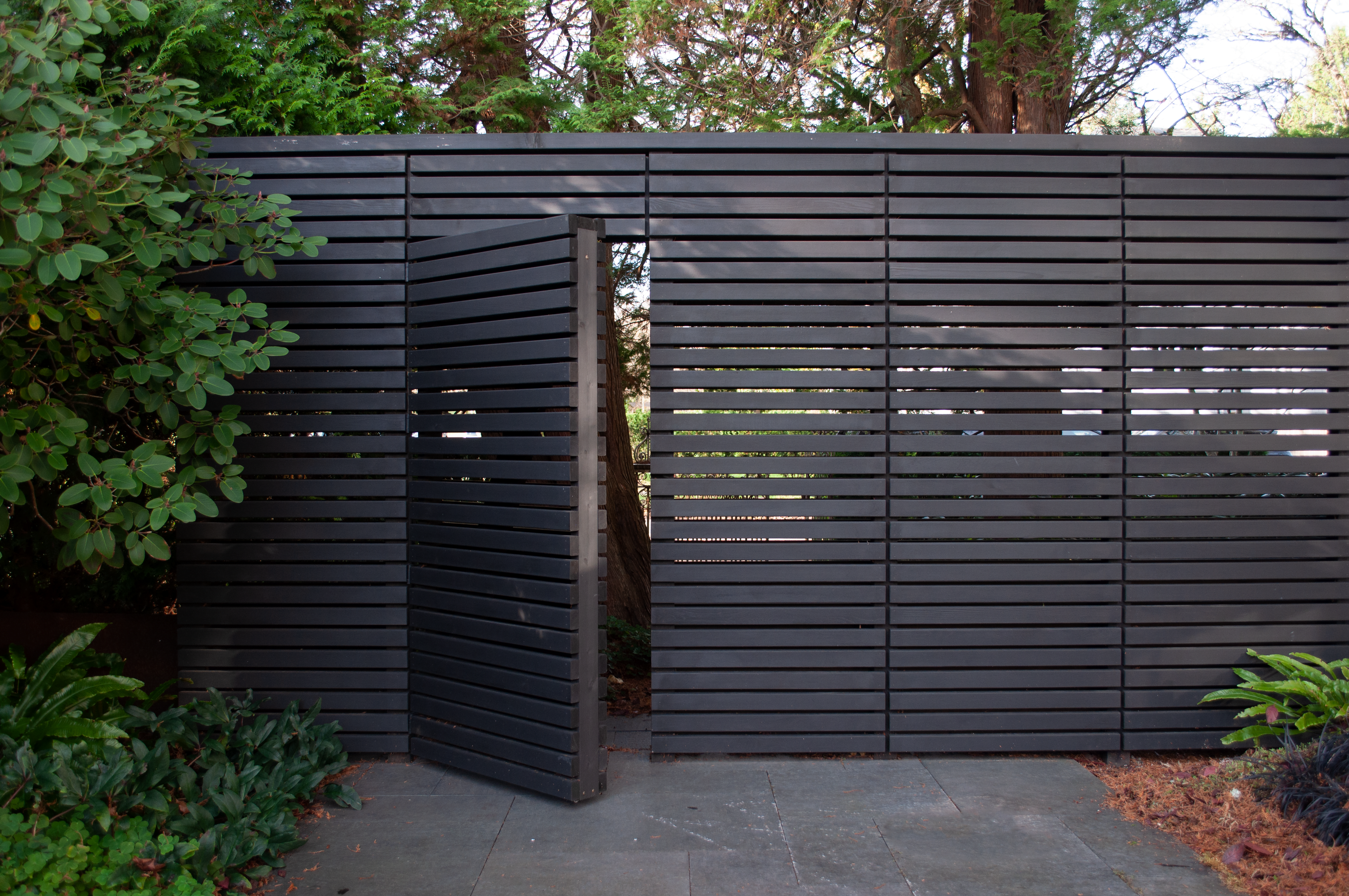 Charcoal stained horizontal cedar privacy screening with gate