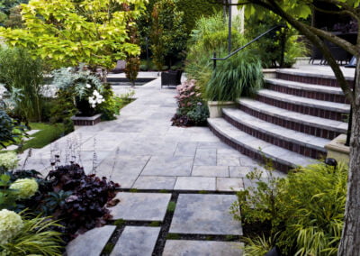 natural stone pool terrace with curved stairs and lush planting