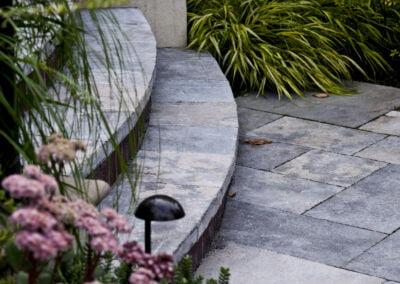 Curved natural stone stair treads and landing with planting