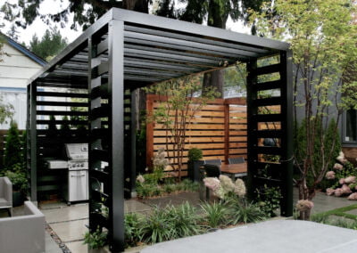 Landscape construction project in Vancouver, BC. Garden terrace with metal pergola covering a BBQ.