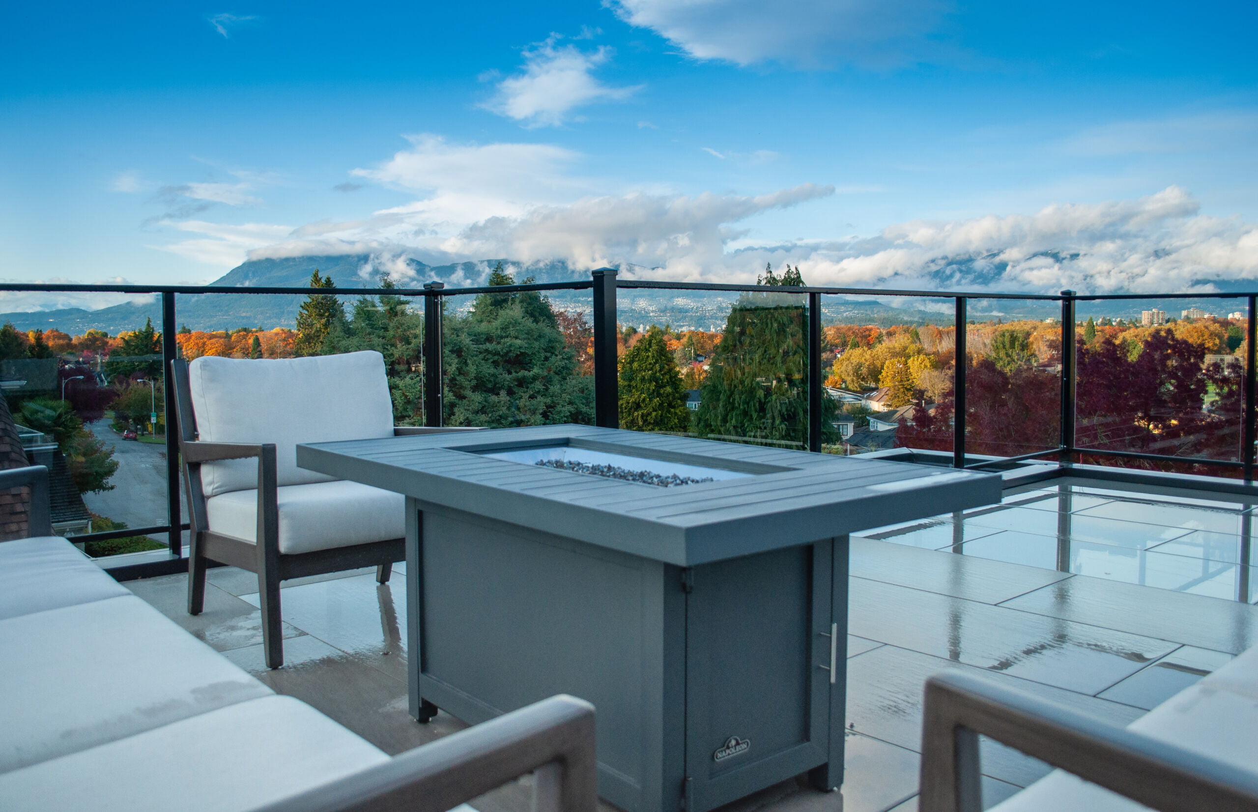roof deck fire table with chairs and view overlooking city with fall colours