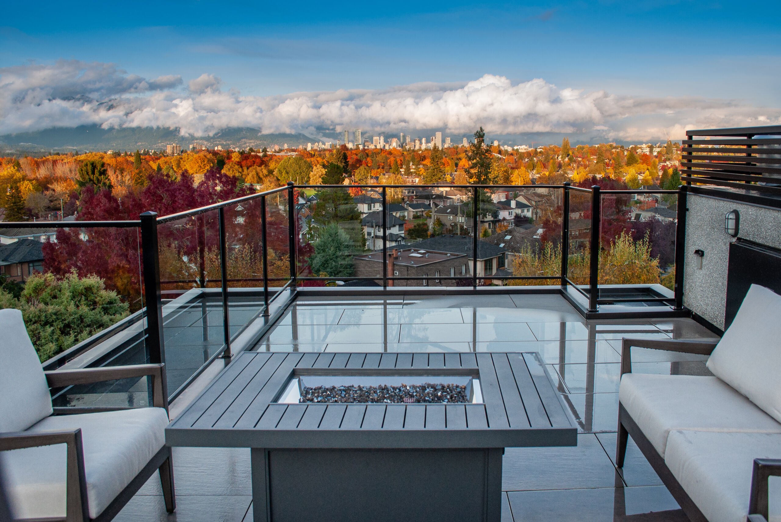 Roof deck fire table overlooking city of vancouver and mountains with fall colours