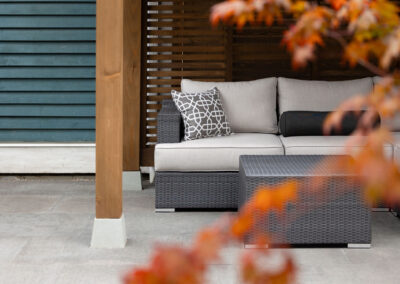 Modern backyard design in Vancouver with stone patio and wood pergola.